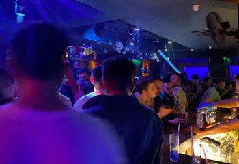 Tek Yon Club Istanbul: Gay men at a crowded bar with drinks, disco balls, and blue lighting. Istanbul's gay nightlife scene.