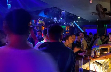 Tek Yon Club Istanbul: Gay men at a crowded bar with drinks, disco balls, and blue lighting. Istanbul's gay nightlife scene.