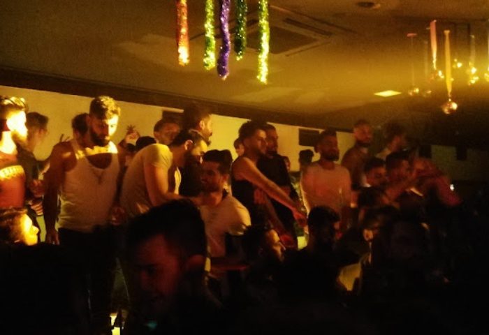 Tek Yon Club Istanbul: Gay men gather in a dimly lit space with decorations. Nightlife scene for gay travel in Istanbul, Turkey.