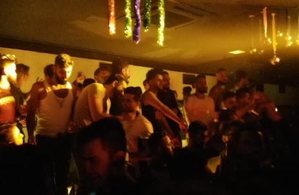 Tek Yon Club Istanbul: Gay men gather in a dimly lit space with decorations. Nightlife scene for gay travel in Istanbul, Turkey.