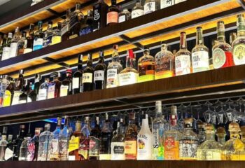 Bar shelves stocked with spirits at Terroir Wine Bar, Ho Chi Minh City. A gay travel destination offering a variety of alcoholic beverages.