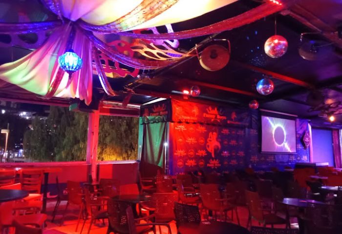 Terry's Show Bar, a gay bar in Gran Canaria. Interior view with tables, chairs, stage backdrop, disco balls, and colorful lighting.