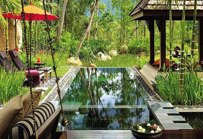Four Seasons Resort Chiang Mai pool view. Thai design luxury hotel with river, mountain backdrop. Gay travel destination.