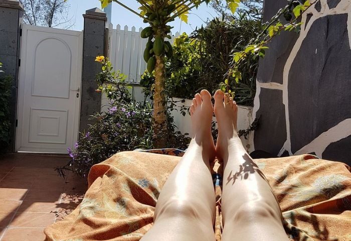 Relaxing in Gran Canaria. Legs of a person on a lounger, enjoying the sun. Gay massage travel destination. Thai Holistic massage.