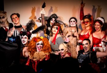 The 86 Melbourne: Group of drag queens in costume at a gay bar. Halloween-themed party with unique makeup and outfits. Melbourne travel.