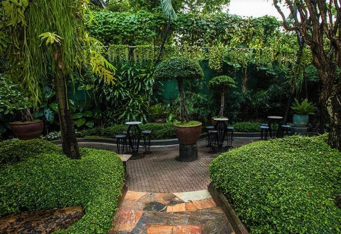 Babylon Bangkok Hotel's lush garden. This gay men-only hotel and sauna offers a tranquil outdoor space. Perfect for relaxing in Bangkok.