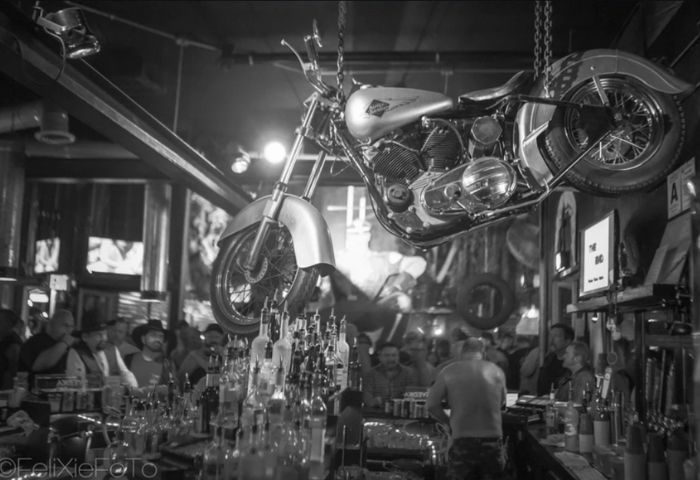 The Barracks: B/W shot of a motorcycle hanging above the bar at this popular gay bar. Great spot for gay men's travel.