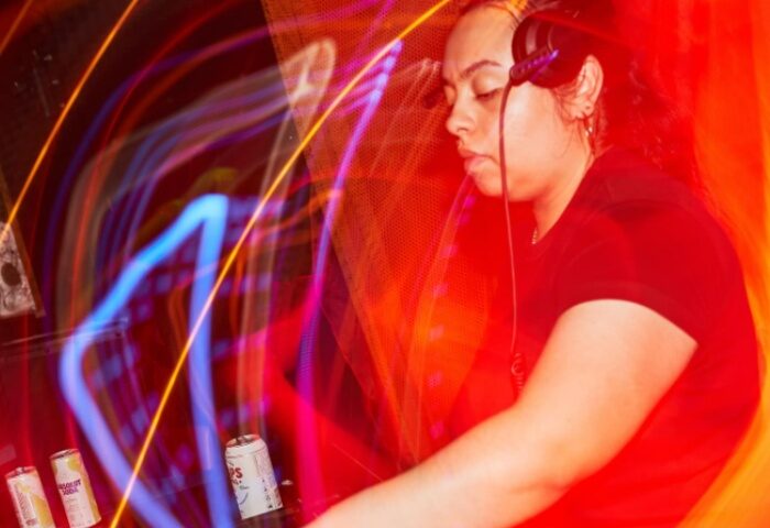 The Bearded Tit Sydney: A DJ with headphones plays music in a vibrant, colorful gay bar in Sydney. Nightlife and travel advice for gay men.