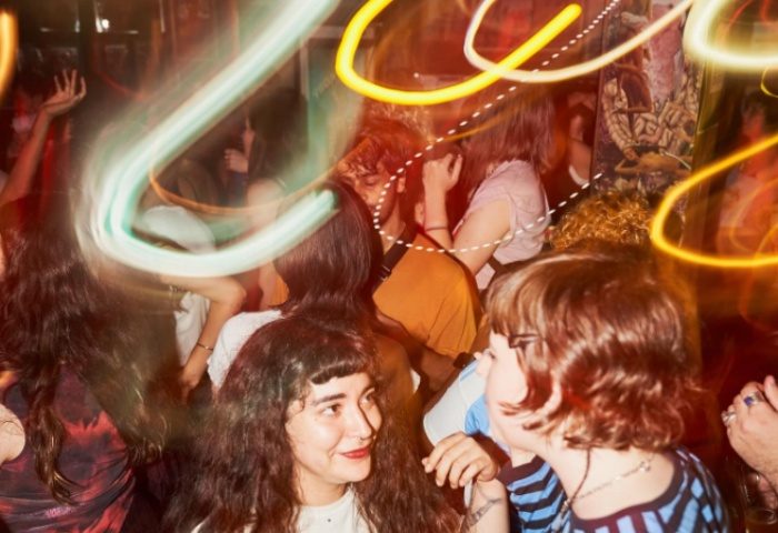 Crowd at The Bearded Tit, Sydney. Gay bar scene with people dancing, blurred lights, and a lively atmosphere. Gay travel advice.