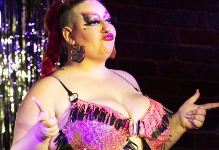 Bearded Tit Sydney drag queen, performing for gay men's travel. Braided red hair, sparkly bra, paw print earrings. Queer nightlife.