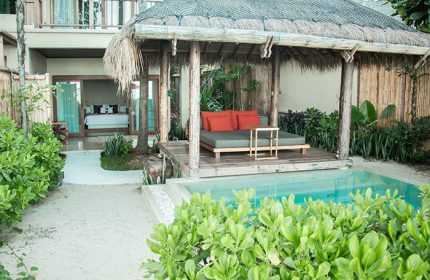 Anantara Rasananda Koh Phangan Villas' private pool villa. Best villa for gay travelers. Daybed under a thatched roof, pool, and bedroom view.