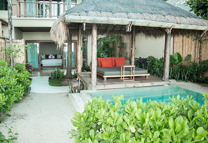 Anantara Rasananda Koh Phangan Villas' private pool villa. Best villa for gay travelers. Daybed under a thatched roof, pool, and bedroom view.