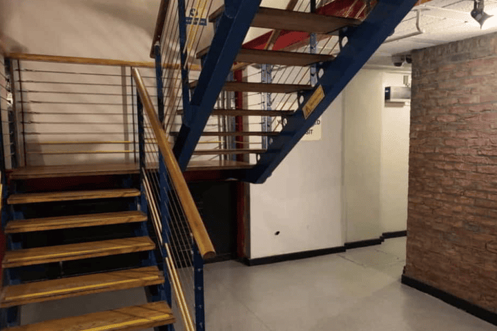 Staircase inside The Boilerhouse gay sauna in Dublin. Blue metal frame, wooden steps and handrail. Gay travel advice.