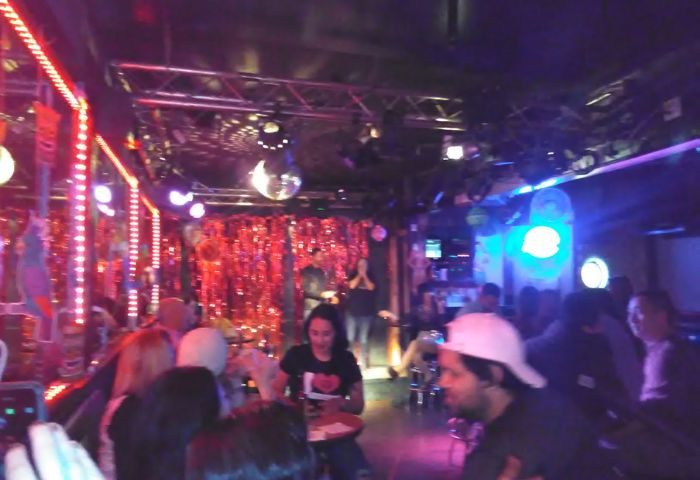 The Boulevard Bar experience: Gay bar interior with disco balls, stage, and crowd. Nightlife scene, a gay men travel destination.