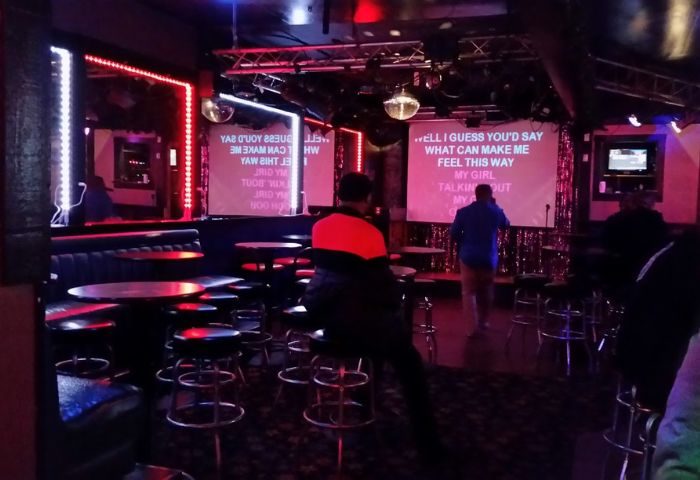 The Boulevard Bar karaoke night. Gay bar interior with karaoke screens, bar stools, and disco balls. Nightlife for gay men travelers.