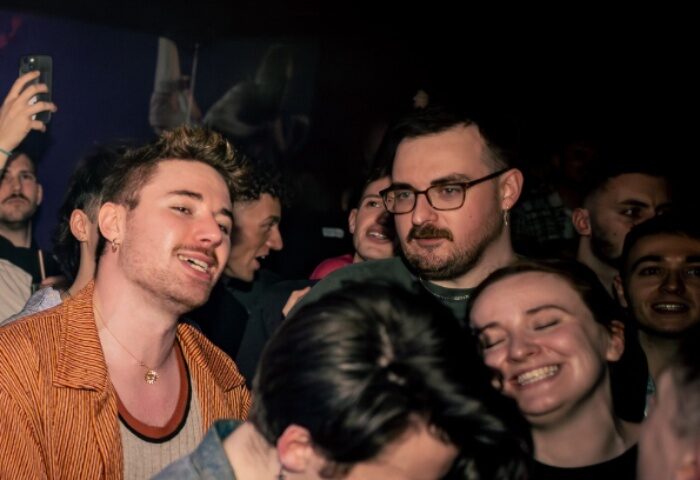 Gay nightlife at The Brewers in Manchester. A crowd of diverse people smiling and enjoying a night out at this popular gay bar.