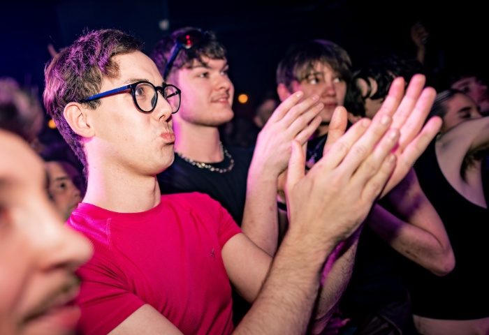 Gay men at The Brewers Manchester, clapping. Nightlife scene, travel advice. Crowd enjoying the show, vibrant atmosphere.