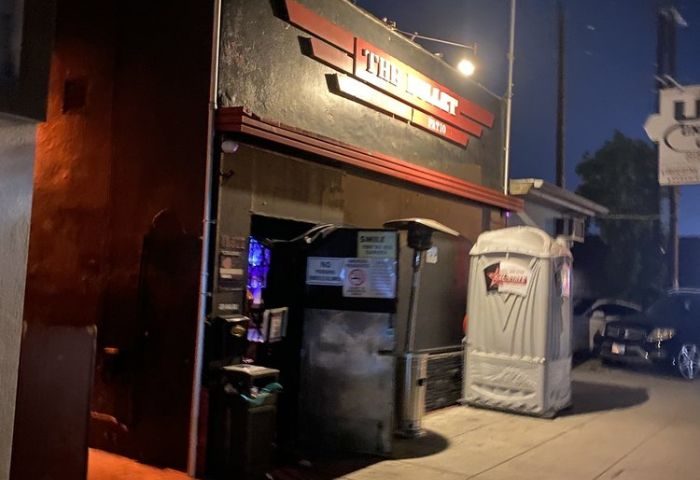 The Bullet Bar location exterior. Gay bar, nightlife, and travel. Dark building with The Bullet sign. Street view of a gay bar.