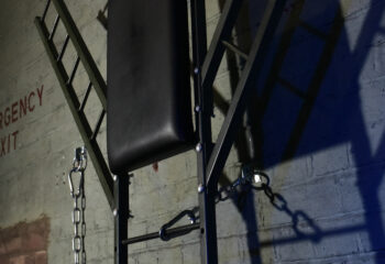 The Bunker London's private appointment only gay cruise club. Interior shot of a dungeon with chains and emergency exit sign.