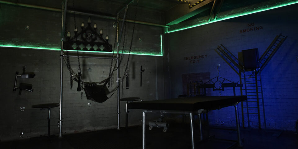 The Bunker London private appointment only. Gay cruise club interior with chains, bed, and emergency exit. Gay travel advice.