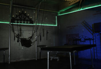 The Bunker London private appointment only. Gay cruise club interior with chains, bed, and emergency exit. Gay travel advice.