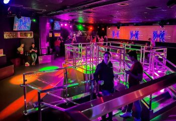 The Cafe Night Club in San Francisco. Gay bar interior with colorful lighting, DJ, dance floor, and men socializing. Gay nightlife travel.