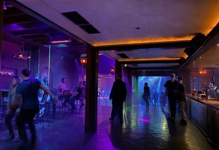 The Chapel @ The Abbey floor. Gay men enjoy the club's vibrant nightlife, with purple and blue lighting, bar, and dance floor.