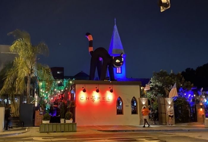 The Chapel @ The Abbey outside view at night. Halloween decor, with a giant black cat on the roof. Gay travel destination.