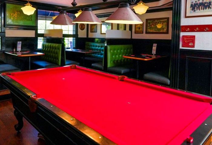 The Church Mouse Pub in Toronto: Interior view with a red pool table, booths, and lighting. A gay-friendly bar for travelers.