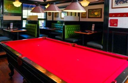 The Church Mouse Pub in Toronto: Interior view with a red pool table, booths, and lighting. A gay-friendly bar for travelers.
