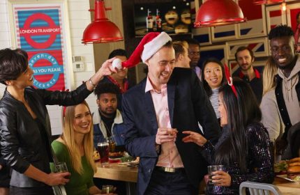 Festive group at The Church Mouse Pub in Toronto. People are celebrating, one wearing a Santa hat. Gay travel advice.