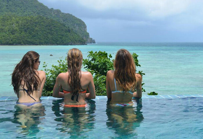 Cobble Beach Hotel, Koh Phi Phi. Women in rooftop pool overlooking beachfront. Cheap, gay-friendly hotel. Tropical vacation vibes.