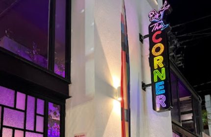 The Corner Bar neon sign, a gay place in Puerto Vallarta, Mexico, with colorful lights and a cocktail glass icon, inviting gay travelers.