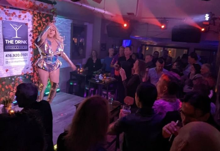 A drag queen performs at The Drink Cocktail Pizza Bar in Toronto. A gay bar with a lively atmosphere and a diverse crowd. Gay travel.