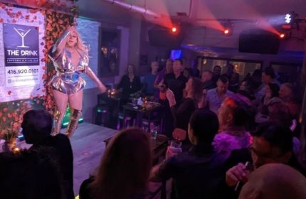 A drag queen performs at The Drink Cocktail Pizza Bar in Toronto. A gay bar with a lively atmosphere and a diverse crowd. Gay travel.