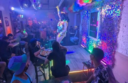 Nightlife at The Drink: Toronto's gay bar with drag shows, cocktails, pizza, and a vibrant atmosphere. A must-visit for gay men's travel.