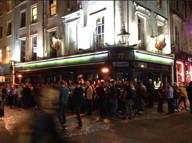 The Duke of Wellington gay bar in London. Crowd of men outside the pub at night. Gay travel destination.