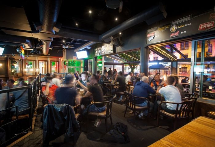 Interior of The Fountainhead Pub in Vancouver. People sit at tables in the gay-friendly bar. Nightlife travel advice.
