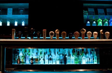 The Fountainhead Pub in Vancouver bar. Bottles and taps are backlit with blue light. Gay travel advice.