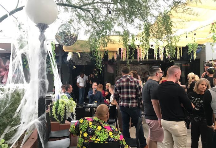 The Garden Las Vegas gay bar scene. Outdoor patio with men, disco ball, and Halloween decor. Gay travel advice for nightlife.