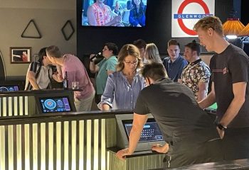 The Glenwood gay bar in Chicago: A lively scene with patrons at the bar, enjoying drinks and socializing in a welcoming atmosphere.