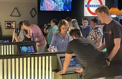 The Glenwood gay bar in Chicago: A lively scene with patrons at the bar, enjoying drinks and socializing in a welcoming atmosphere.