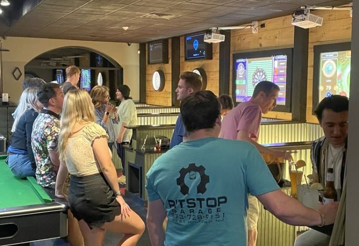The Glenwood gay bar in Chicago: patrons socializing, playing darts, and drinking. Nightlife scene with a relaxed, friendly atmosphere.