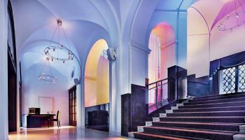 The Grand Mark Prague luxury hotel lobby with arched ceilings, chandeliers, and staircase. Popular honeymoon choice for gay couples.