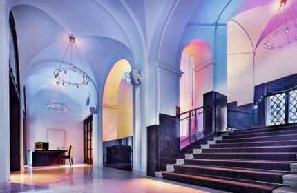 The Grand Mark Prague luxury hotel lobby with arched ceilings, chandeliers, and staircase. Popular honeymoon choice for gay couples.