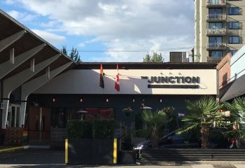 The Junction Pub in Vancouver. Gay bar with rainbow flag and Canadian flag. Gay travel destination for men in Vancouver, Canada.