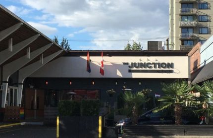 The Junction Pub in Vancouver. Gay bar with rainbow flag and Canadian flag. Gay travel destination for men in Vancouver, Canada.