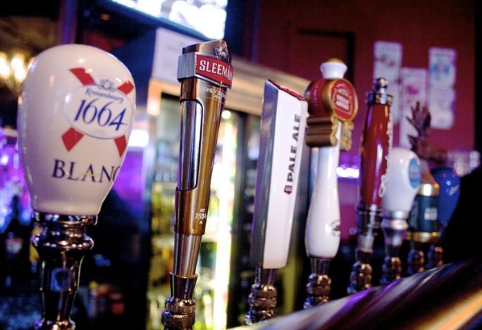 Close-up of beer taps at The Junction Pub in Vancouver. Sleeman, 1664 Blanc, Pale Ale. Gay travel advice, nightlife.