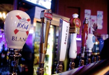 Close-up of beer taps at The Junction Pub in Vancouver. Sleeman, 1664 Blanc, Pale Ale. Gay travel advice, nightlife.