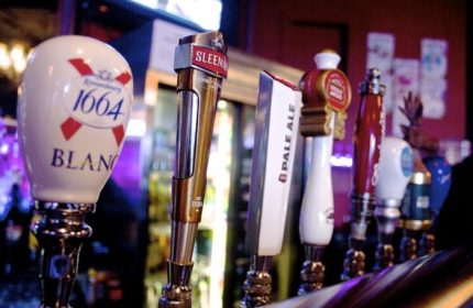 Close-up of beer taps at The Junction Pub in Vancouver. Sleeman, 1664 Blanc, Pale Ale. Gay travel advice, nightlife.